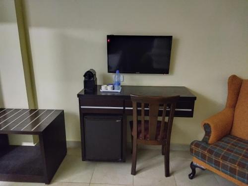 瓦迪穆萨Rendezvous hotel petra的客房设有书桌、电视和椅子