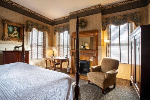 萨凡纳Foley House Inn的一间卧室配有一张床、一把椅子和一张桌子