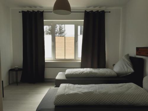 新明斯特Nordunterkunft的两张床位于带窗户的房间内