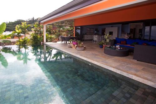 普纳奥亚Magnifique Villa Vue Mer exceptionnelle - Ireina的游泳池毗邻带客厅的房屋