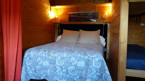 韦尔东河畔拉帕吕Ferme de Bourras的木墙客房的一张床位