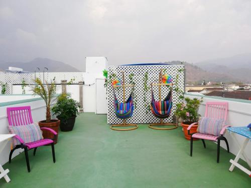 危地马拉安地瓜La Quinta Santa Lucia的阳台配有两把椅子和一张桌子,还有一些植物