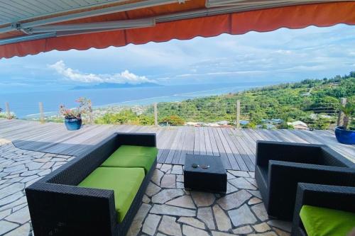 普纳奥亚VILLA BOUNTY AMAZING OCEAN VIEW的天井配有绿色沙发和桌子
