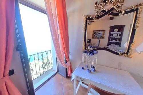 皮佐B&B Casa Angelieri的客房设有镜子、桌子和窗户。