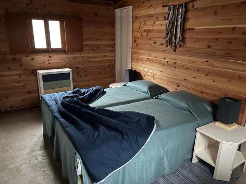 英雄港A Cabana的木制客房内的一间卧室配有一张大床
