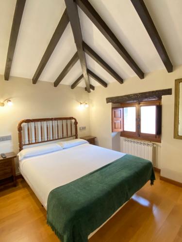 利亚内斯La Casina de la Arquera的卧室配有一张带绿毯的大型白色床