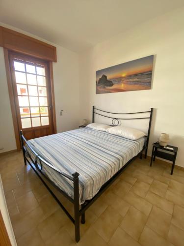 丽都玛里尼Appartamento "L'Ulivo" a Lido Marini的一间带床的卧室,位于带窗户的房间内