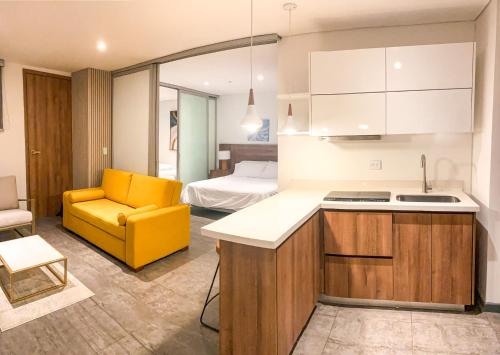 巴兰基亚Gz Tower Apartamento Barranquilla的一间带黄色椅子的厨房和一间带床的房间
