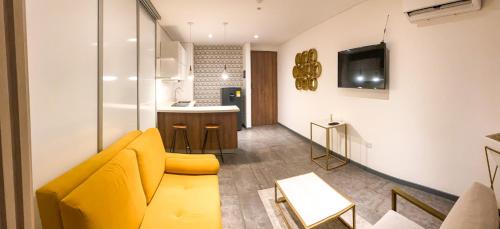 巴兰基亚Gz Tower Apartamento Barranquilla的一间带黄色沙发的客厅和一间厨房