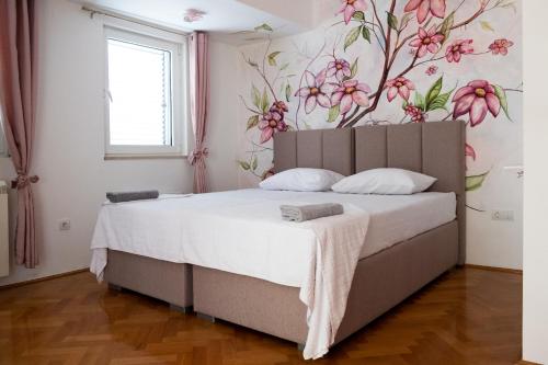 布德瓦Guest House Mrvaljević的卧室配有一张挂着花壁画的床。