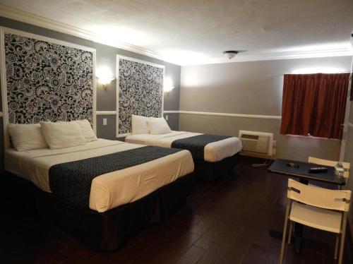 长滩Hotel Salina的酒店客房配有两张床和一张书桌
