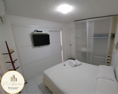 圣路易斯American Flat - Ponta D'areia - Ferreira Hospedagens的一间白色的小卧室,配有床和电视