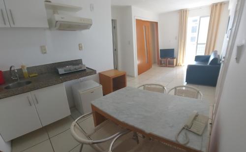 圣路易斯American Flat - Ponta D'areia - Ferreira Hospedagens的厨房以及带桌椅的起居室。