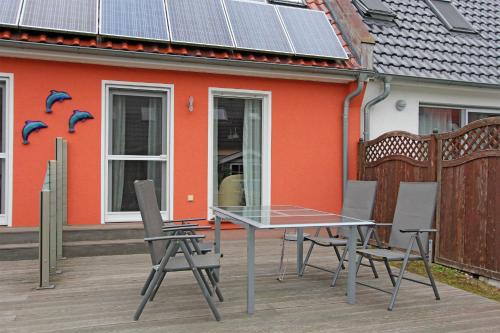 普鲁滕Ferienhaus Pruchten FDZ 311的桌椅位于带太阳能电池板的房子前