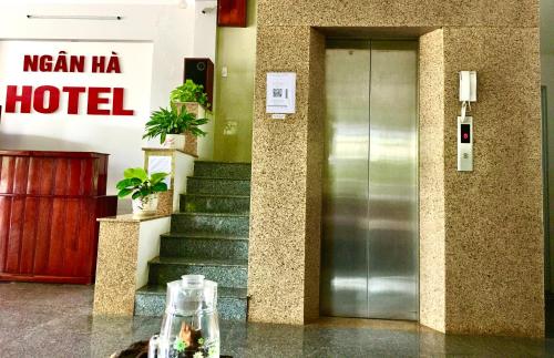 绥和市khách sạn Ngân Hà的酒店大堂设有玻璃门和楼梯
