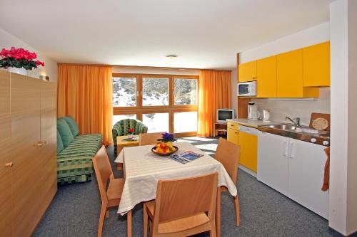 奥伯古格尔博赛公寓酒店的厨房以及带桌椅的用餐室。