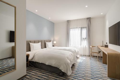台中市台中凤凰酒店的酒店客房设有一张大床和一张书桌。