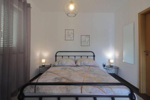 奥米沙利Apartman Studio Pesja的一间卧室配有一张床,两台桌子上放着两盏灯