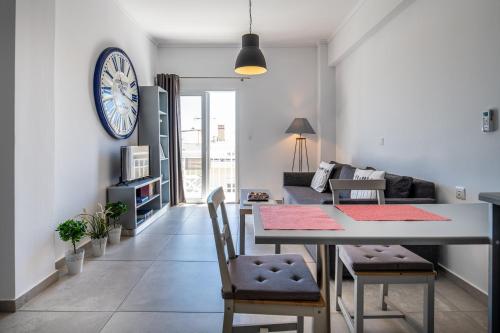 科斯镇Milva Apartments的客厅配有桌子和墙上的时钟