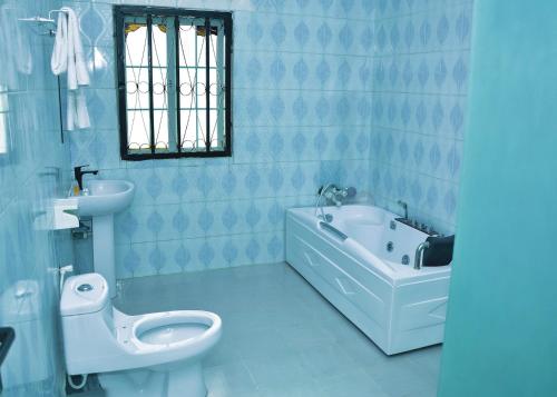 Ado EkitiTRAVELLERS HOMELY的浴室配有卫生间、浴缸和水槽。