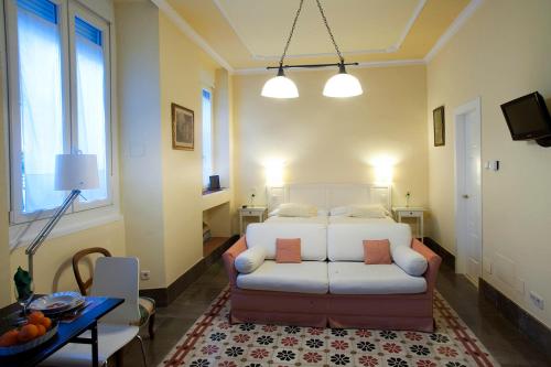 格拉纳达帕拉西奥洛佩兹达扎公寓的客厅配有沙发和1张床