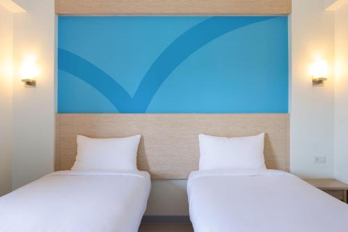 宿务Hop Inn Hotel Cebu City的两张睡床彼此相邻,位于一个房间里