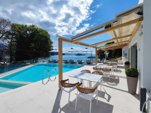 帕尔加Alboro seaside suites的游泳池旁带桌椅的天井