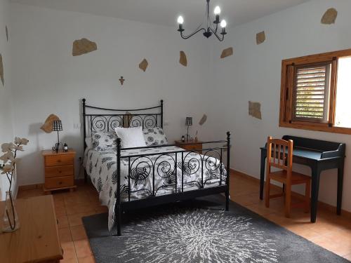 巴尔塞基略Peaceful house set on a vineyard & work friendly的卧室配有床、书桌和钢琴