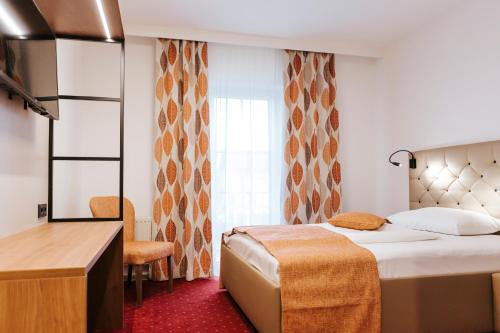 乌特普伦斯塔滕Hotel Der Stockinger的一间设有大床和窗户的酒店客房