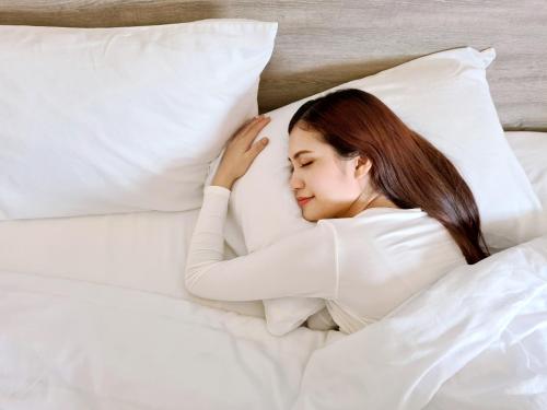 宿务Hop Inn Hotel Cebu City的躺在床上的女士,带枕头