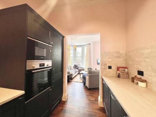 布里斯托Redland Suites - Apartment 4的一间厨房、一个黑色橱柜和一间客厅