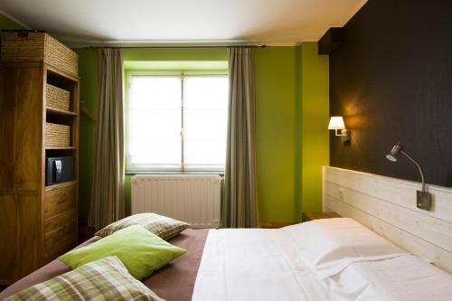 AwenneLa Fontaine du Sabotier的一间卧室设有一张带绿色墙壁和窗户的床。