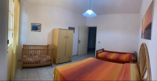 兰佩杜萨Lopadusa trilo 1的一间卧室配有两张床和一张婴儿床。
