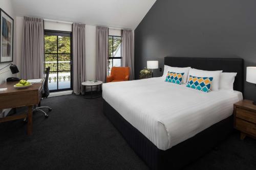 弗里曼特弗里曼特尔滨海莱吉斯酒店的一间卧室配有一张大床、一张书桌和窗户。