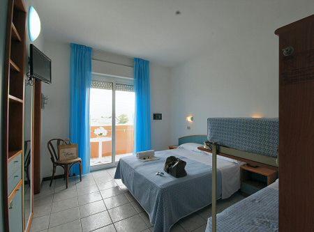 阿尔巴·阿德里亚蒂卡HOTEL BALTIC的一间卧室配有床和蓝色窗帘的窗户