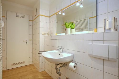 博尔滕哈根Dünenblick Wohnung 51的白色的浴室设有水槽和镜子