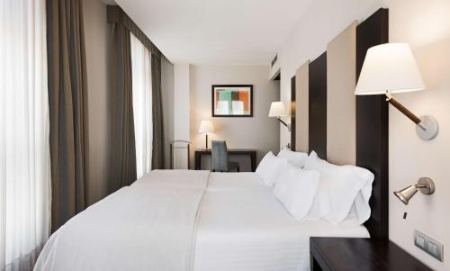 卡塔赫纳Hotel Cartagena Puerto的卧室配有一张白色大床和一张书桌