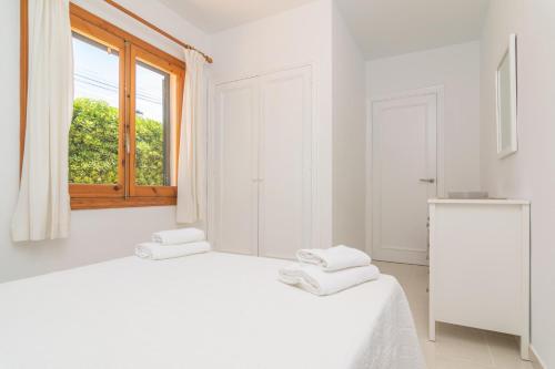 卡拉恩波特Villa Marina -Cala EnPorter-的白色的卧室设有床和窗户
