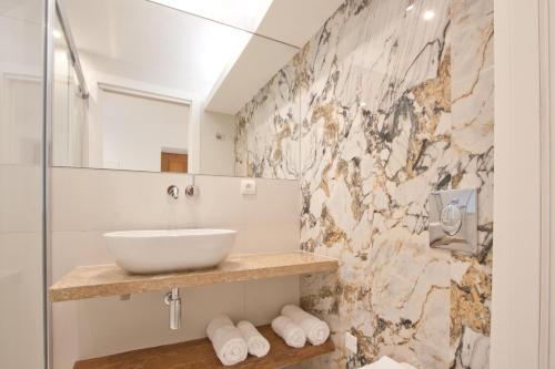 博尼法乔Studio cozy sur la Marina de Bonifacio的一间带水槽和大理石墙的浴室