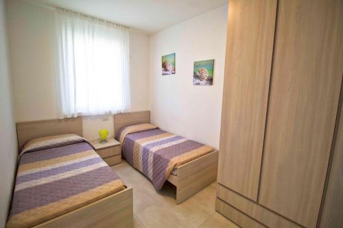 利多迪耶索罗Cala Blu的一间卧室设有两张床和窗户。