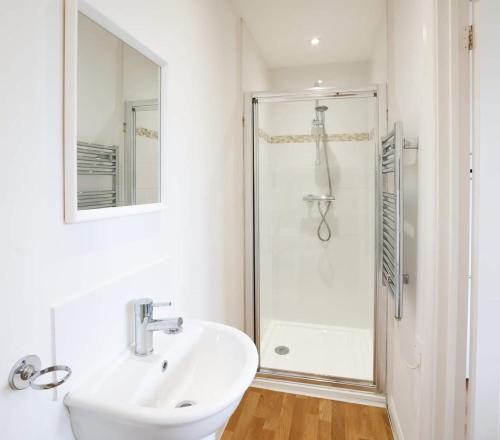 吉尔福德Lovely One Bed Apartment in Guildford的白色的浴室设有水槽和淋浴。