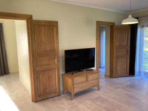 罗亚LUČI jūras apartamenti的客厅设有平面电视和木门。