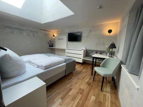 Kraiburg am InnBoutique Hotel Hardthaus的一间卧室配有一张床、一张书桌和一台电视。