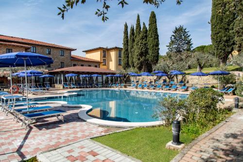 特拉西梅诺湖畔帕西尼亚诺Hotel Villa Paradiso的一个带蓝伞和椅子的大型游泳池