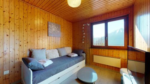 Charming chalet with a splendid view of the Valais mountains的卧室配有木墙内的一张床