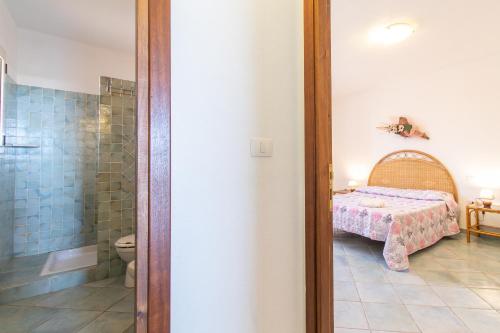 泰斯塔角Elisa Vista Mare的一间卧室配有一张床,浴室设有淋浴。