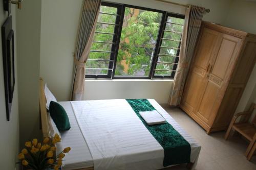 吉婆岛Ngoc Ha Hotel的一间卧室设有一张床和一个大窗户