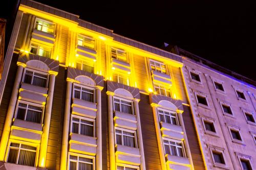 特拉布宗苏梅拉公园酒店的一座晚上有黄色和白色窗户的建筑