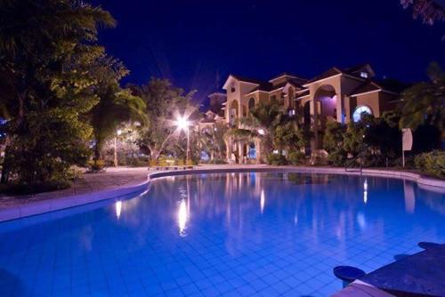 圣克鲁斯Buganvillas Hotel Suites的一座大型游泳池,在晚上在房子前面