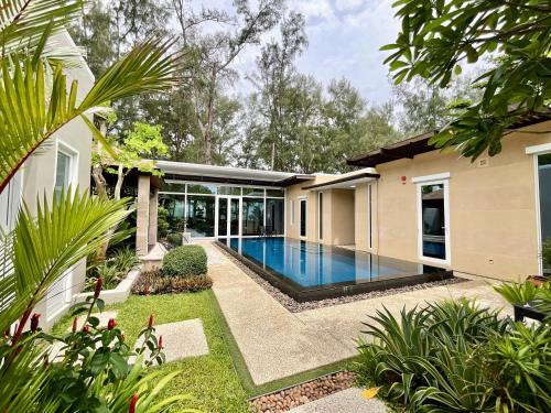 迈考海滩Sunset Ocean Front Villa , Mai Khao Phuket的一座房子后院的游泳池
